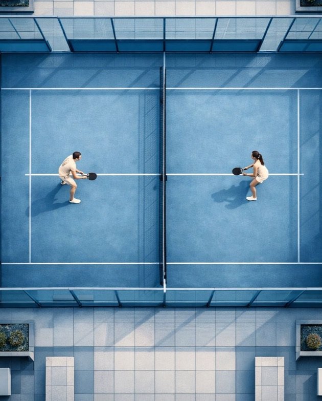 The padel court seen from above, two players mid-rally